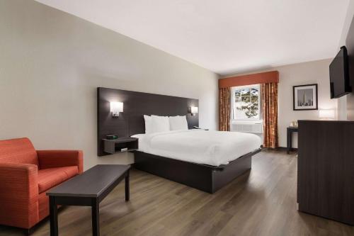 um quarto de hotel com uma cama e uma cadeira em Quality Suites I-44 em Tulsa