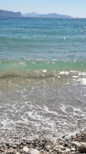 a beach with a wave breaking on the shore at Διαμέρισμα με υπέροχη θέα Porto Cheli Kounoupi in Porto Heli