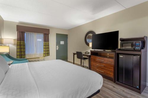 a hotel room with a bed and a flat screen tv at Clarion Pointe Kimball By Choice Hotels in Kimball