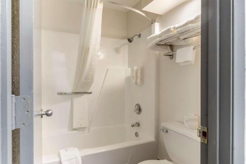 a white bathroom with a shower and a toilet at Clarion Pointe Kimball in Kimball