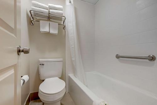 Quality Inn & Suites New Hartford - Utica في أوتيكا: حمام مع مرحاض وحوض استحمام ومغسلة