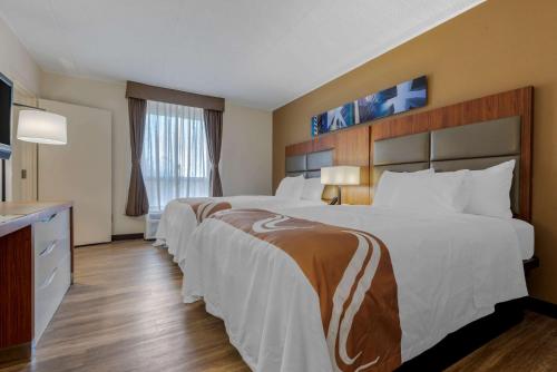 um quarto de hotel com duas camas e uma televisão em Quality Inn & Suites New Hartford - Utica em Utica
