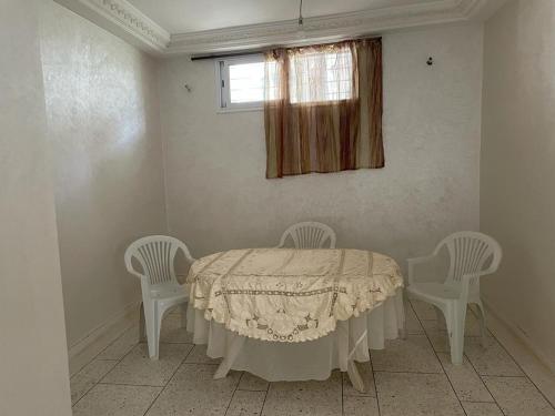 une chambre avec une table, deux chaises et une fenêtre dans l'établissement Sous-sol villa, à Fès