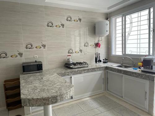 - une cuisine avec un plan de travail en granit et un évier dans l'établissement Sous-sol villa, à Fès