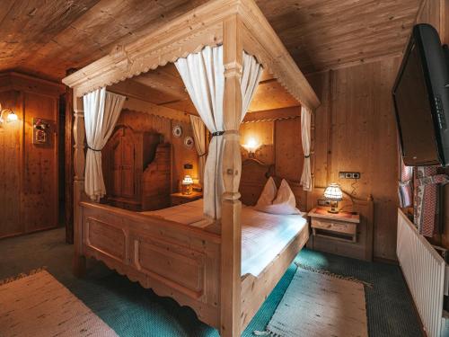 a bedroom with a large bed in a wooden room at Hotel Mitterhof in Gerlos
