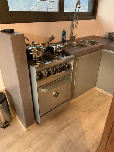 a kitchen with a stove with pots and pans on it at Revolucionarte.Potrerillos in Potrerillos