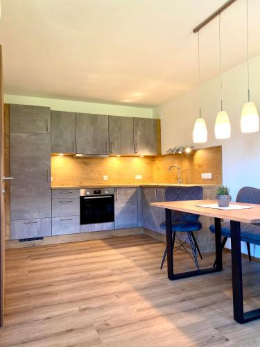 a kitchen with a wooden table and a dining room at Apart Theresa in Fügen