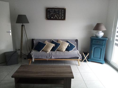 un soggiorno con divano, cuscini e tavolo di Chez Maniche a Cayeux-sur-Mer