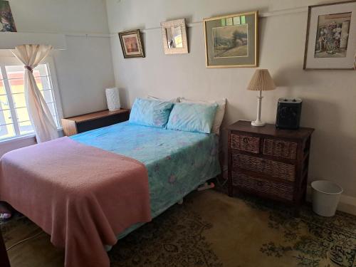 a bedroom with a bed and a table with a lamp at Taste Of Heaven in Bredasdorp