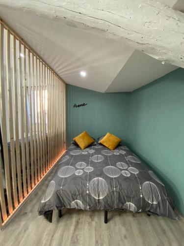 Cama en habitación con pared azul en Appartement loft Manosque, en Manosque