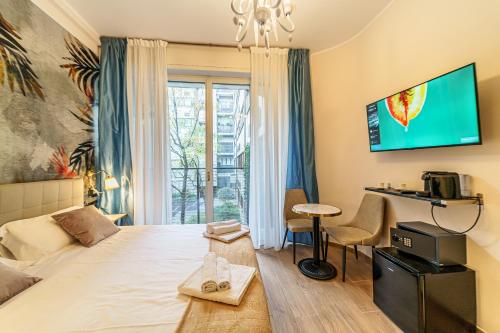 une chambre avec un lit et une télévision au mur dans l'établissement Romana Suites, à Milan