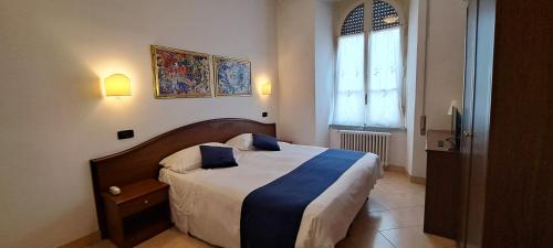 una camera da letto con un grande letto con cuscini blu di Hotel Bonazzi a Perugia