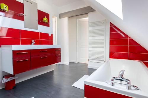 La salle de bains rouge est pourvue d'un lavabo et de placards rouges. dans l'établissement Appartement des Grands Champs avec terrasse, à Saint-Aignan