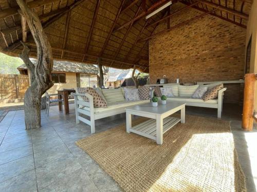 an outdoor patio with couches and a table at Oryx Wilderness Game Lodge and Tented Camp in Rhenosterfontein