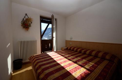 a bedroom with a bed with a colorful blanket at Chalet al Maso in Celledizzo