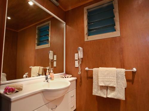 a bathroom with a sink and a mirror at Muri Beach Hideaway - Adults Only in Rarotonga