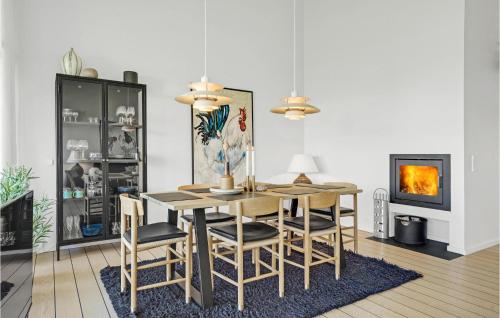 a dining room with a table and chairs and a fireplace at Apartment Nordre Strandvej in Ebeltoft