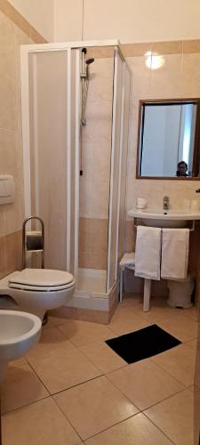 a bathroom with a shower and a toilet and a sink at Hotel Bonazzi in Perugia