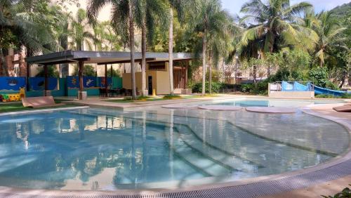 a large swimming pool in a resort with palm trees at Pico De Loro Condo Unit in Nasugbu