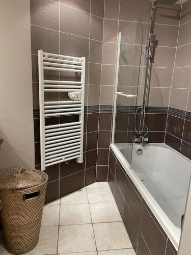 - une salle de bains pourvue d'une baignoire et d'un panier dans l'établissement Appartement sur le parvis de la cathédrale, à Senlis