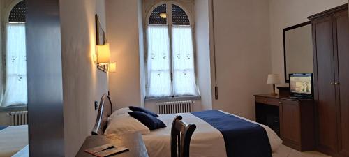 a bedroom with a bed and a table and window at Hotel Bonazzi in Perugia