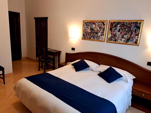 a bedroom with a bed with blue and white sheets at Hotel Bonazzi in Perugia