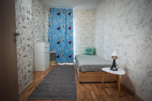 a bedroom with a bed and a table and a refrigerator at Jasmin 2 in Stara Zagora