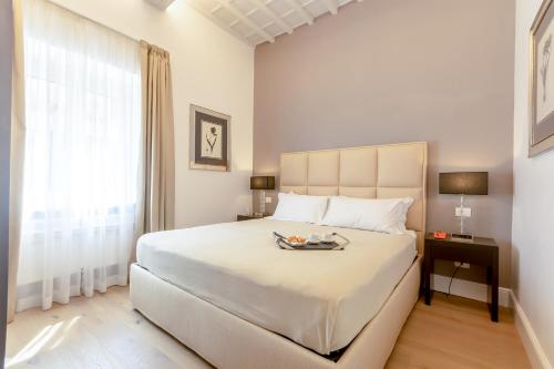 una camera da letto con un grande letto bianco e una finestra di Diva Lodging Luxury - Signoria a Firenze