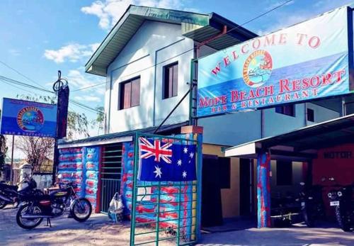 a building with a sign that reads welcome to more british restaurant at Mope Beach Resort in San Narciso