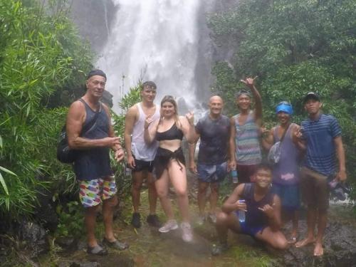 a group of people standing in front of a waterfall at Mope Beach Resort in San Narciso