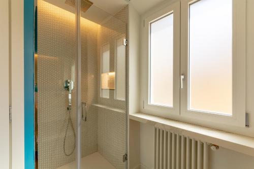 a bathroom with a glass shower with a window at Diva Lodging Luxury - Signoria in Florence