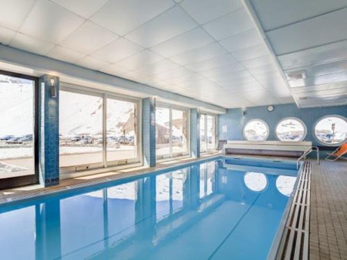 - une piscine d'eau bleue dans une chambre avec fenêtres dans l'établissement Tignes appart 4 pers /piscine/sauna/pied des pistes, à Tignes