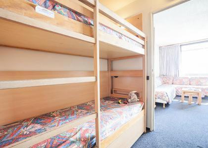 Cet appartement comprend une chambre avec deux lits superposés et un salon. dans l'établissement Tignes appart 4 pers /piscine/sauna/pied des pistes, à Tignes