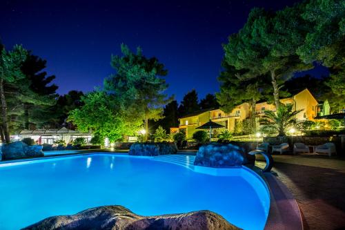 a large swimming pool in a yard at night at Matilde Beach Resort in Vodice