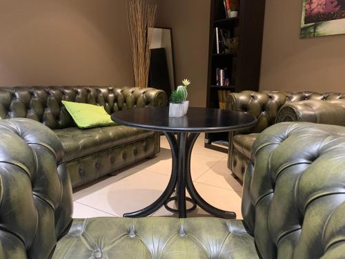 a coffee table in a waiting room with leather couches at Contact Hôtel des États-Unis in Toulouse