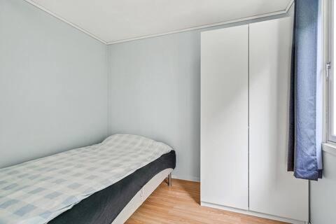 ein Schlafzimmer mit einem Bett und einem weißen Schrank in der Unterkunft Fully equipped independent apartment near NTNU,Lerkendal og center in Trondheim