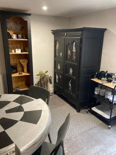 a dining room with a table and a black cabinet at Les Jedis Saint Jean de Losne, La Diligence & escape game immersif in Saint-Jean-de-Losne