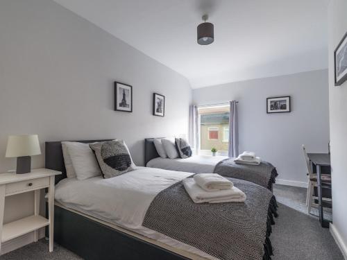 阿士頓的住宿－Chestnut House- 2 Bedroom house in Ashington, Northumberland，一间卧室配有一张床、一张书桌和一个窗户。