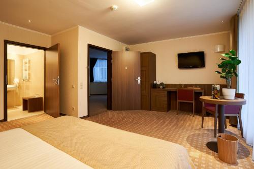 a bedroom with a bed and a table and a desk at Petrodava ONE in Piatra Neamţ