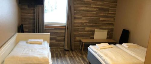 two beds in a room with a brick wall at Kvitfjell Hotel Kvitfjellvegen 492 in Kvitfjell