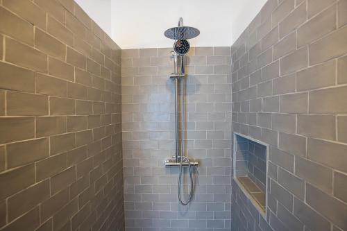 y baño con ducha y azulejos grises. en Apartamentos San Salvador Parking Gratis en Merida