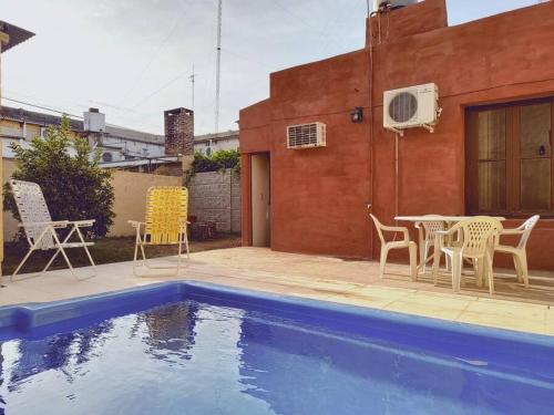 un patio con sillas, una mesa y una piscina en Alquiler temporario Don Floreal en San Antonio de Areco