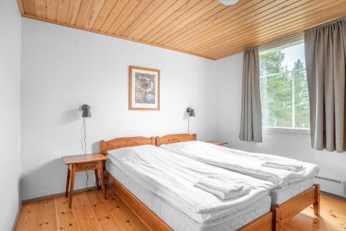 sypialnia z dużym łóżkiem i drewnianym sufitem w obiekcie Hotel K5 Levi and K5 Villas w mieście Levi