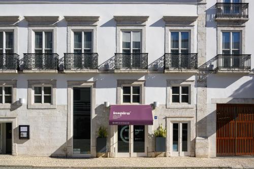 um edifício de apartamentos com um toldo roxo em Inspira Liberdade Boutique Hotel em Lisboa