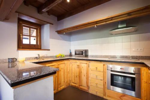 a kitchen with wooden cabinets and a stove top oven at Tarter Chalets Apartaments in El Tarter