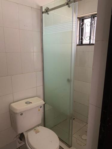 uma casa de banho com um WC e uma cabina de duche em vidro. em Our Nice Home em Kaduna