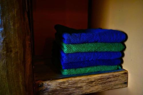 een stapel blauwe en groene handdoeken op een plank bij Privéparadijs,Houtvuur,Ongerepte natuur, Ardennen. in Éteignières