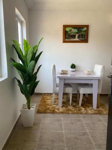 una sala da pranzo con tavolo bianco e pianta di Our Nice Home a Kaduna