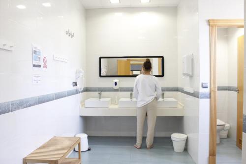 a woman standing at a sink in a bathroom at Hostel Águilas Isla del Fraile in Águilas