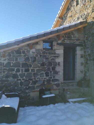 a stone building with a window and snow in front of it at Studio "les planchettes" in Fay-sur-Lignon